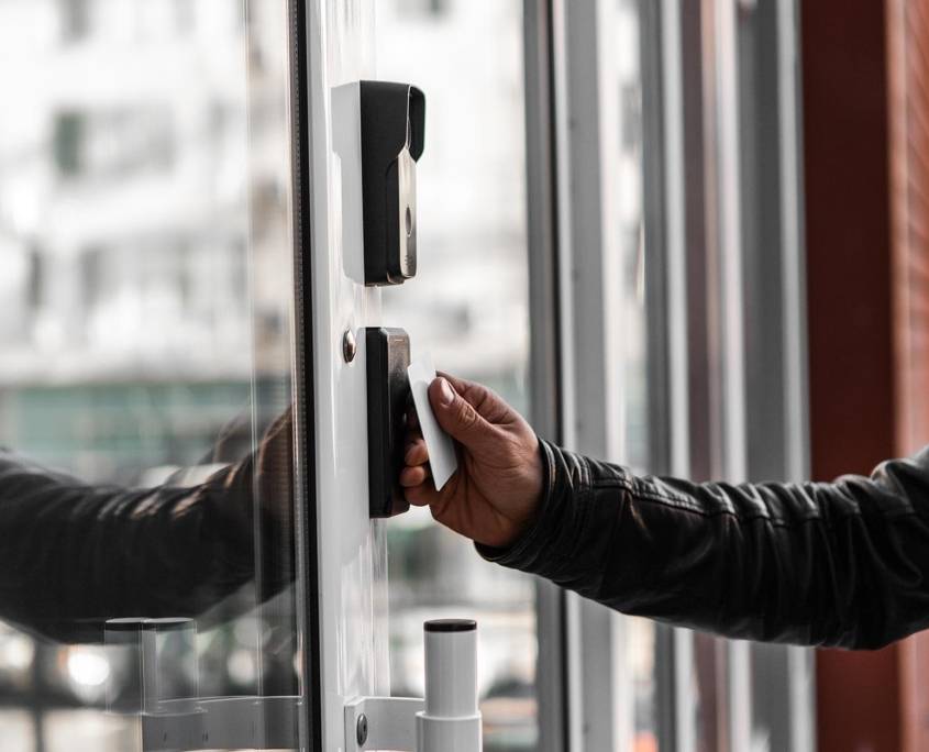Side view of someone holding up a card to a smart lock mechanism
